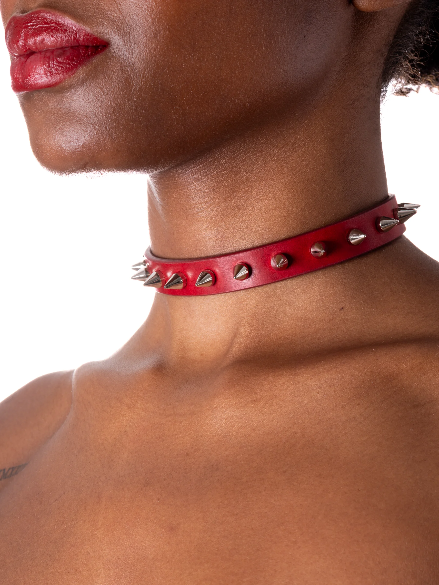 Model is wearing a red gothic collar with spikes and rivets