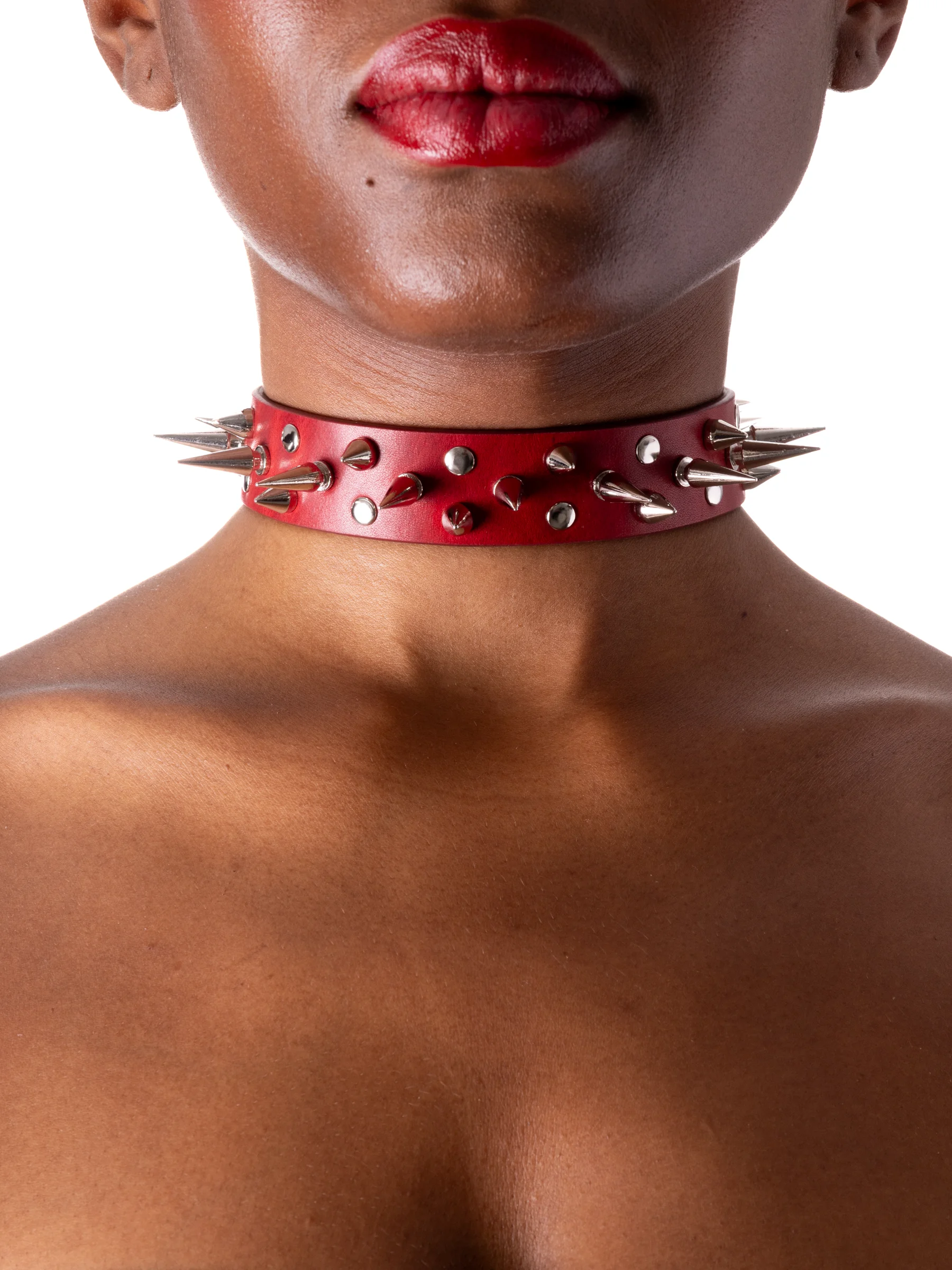 Model is wearing a red gothic collar with spikes and rivets